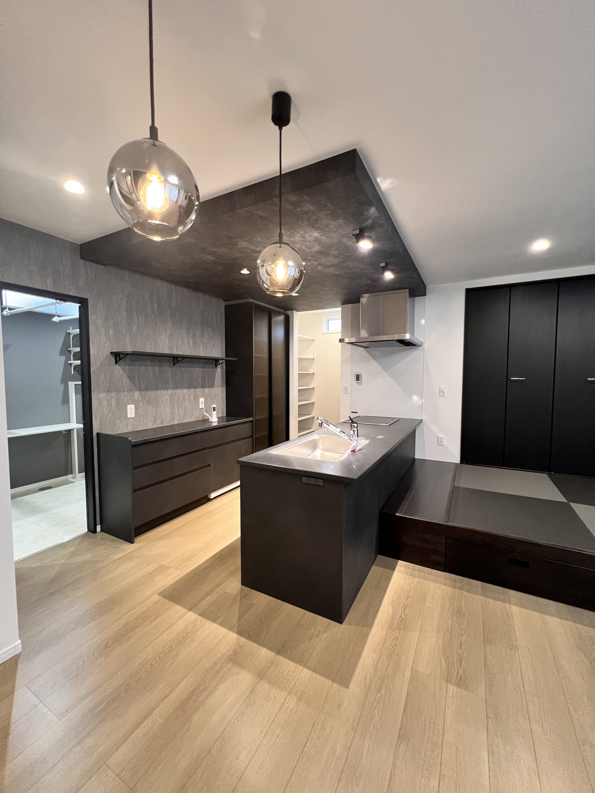 ペニンシュラスタイルのオープンキッチン、奥にパントリー